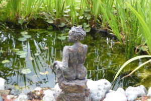 seated figure by the pond