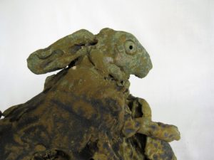 Hare leaping round rock,, ceramic sculpture