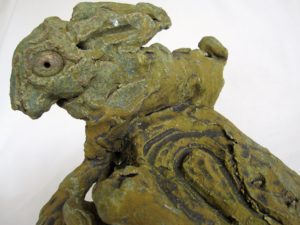 Hare leaping round rock,, ceramic sculpture